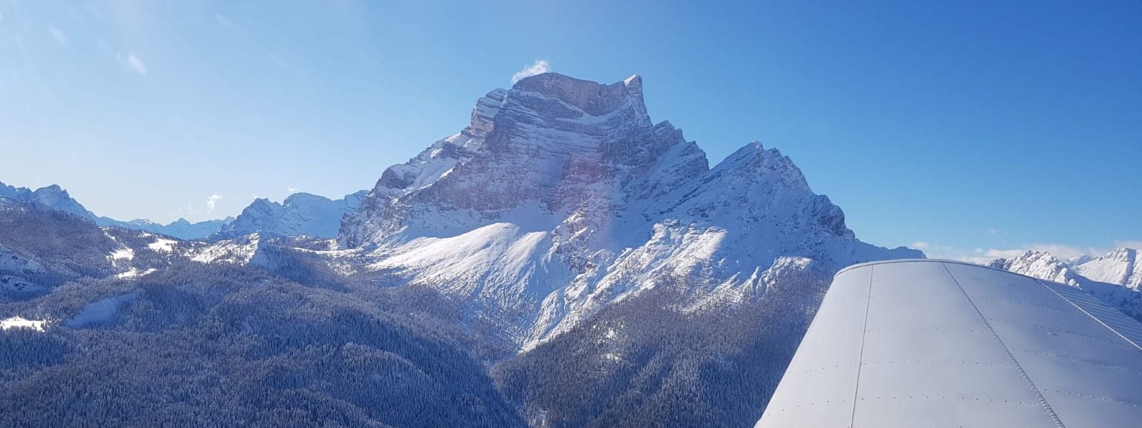 Aereo in avvicinamento a un'aviosuperficie in pendenza fra le montagne